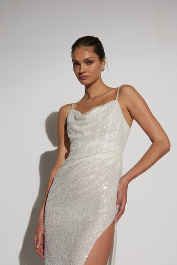 Wedding dress Crafted in a luxurious ivory hue & adorned with intricate embellishments, this dress captivates with its flattering cowl neck, a high slit and a flowing skirt.
