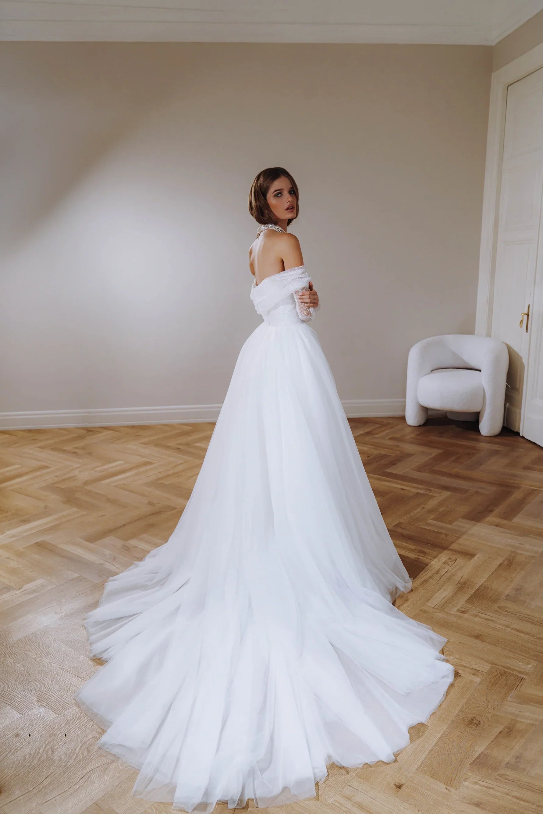 Form fitting wedding dress with long detachable sleeves, can be worn together with a full tulle skirt. Zipper back.