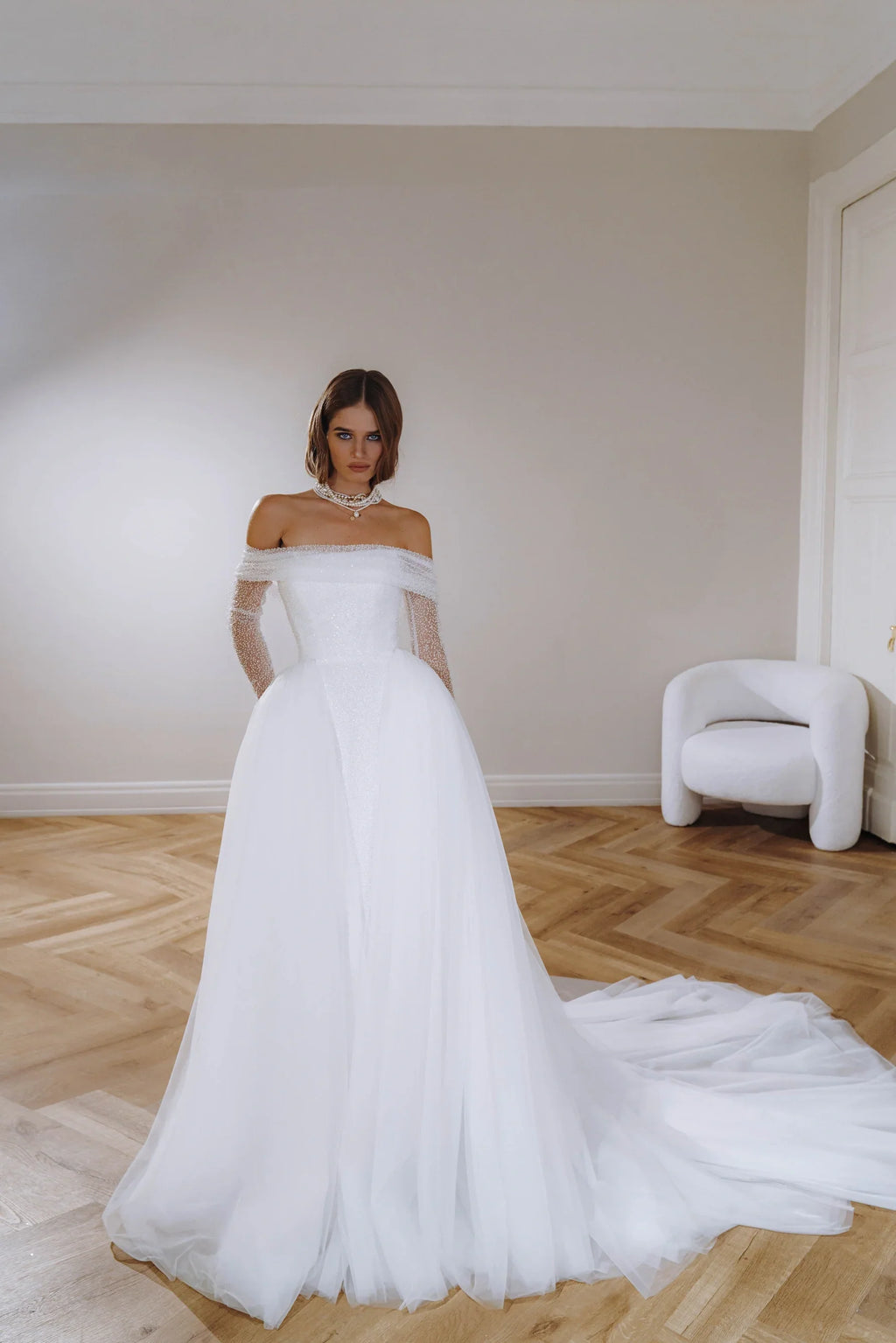 Form fitting wedding dress with long detachable sleeves, can be worn together with a full tulle skirt. Zipper back.