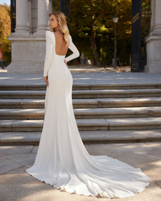 Sexy long mermaid wedding dress crafted in stretch crêpe. A square neckline, plunging back and long sleeve complete the look. An on-trend Luna Novias look.