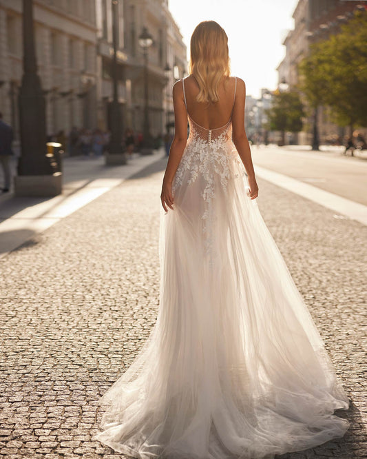 Long princess wedding dress crafted in tulle, lace and beadwork. The V-neckline, plunging back and straps complete the look.