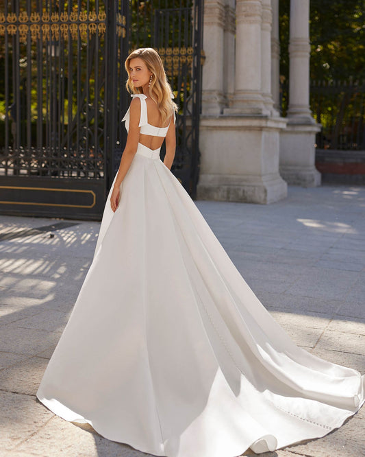 Classic long wedding dress crafted in satin. A square neckline, cut-out back and tie straps complete the look.